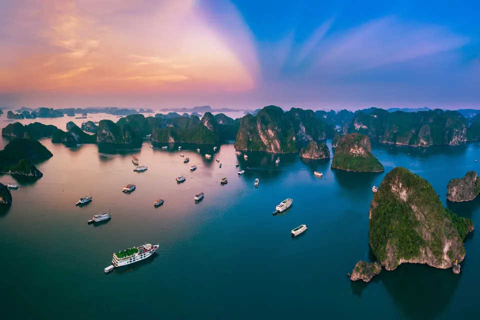 Kalkstensøer i Ha Long-bugten i solnedgang