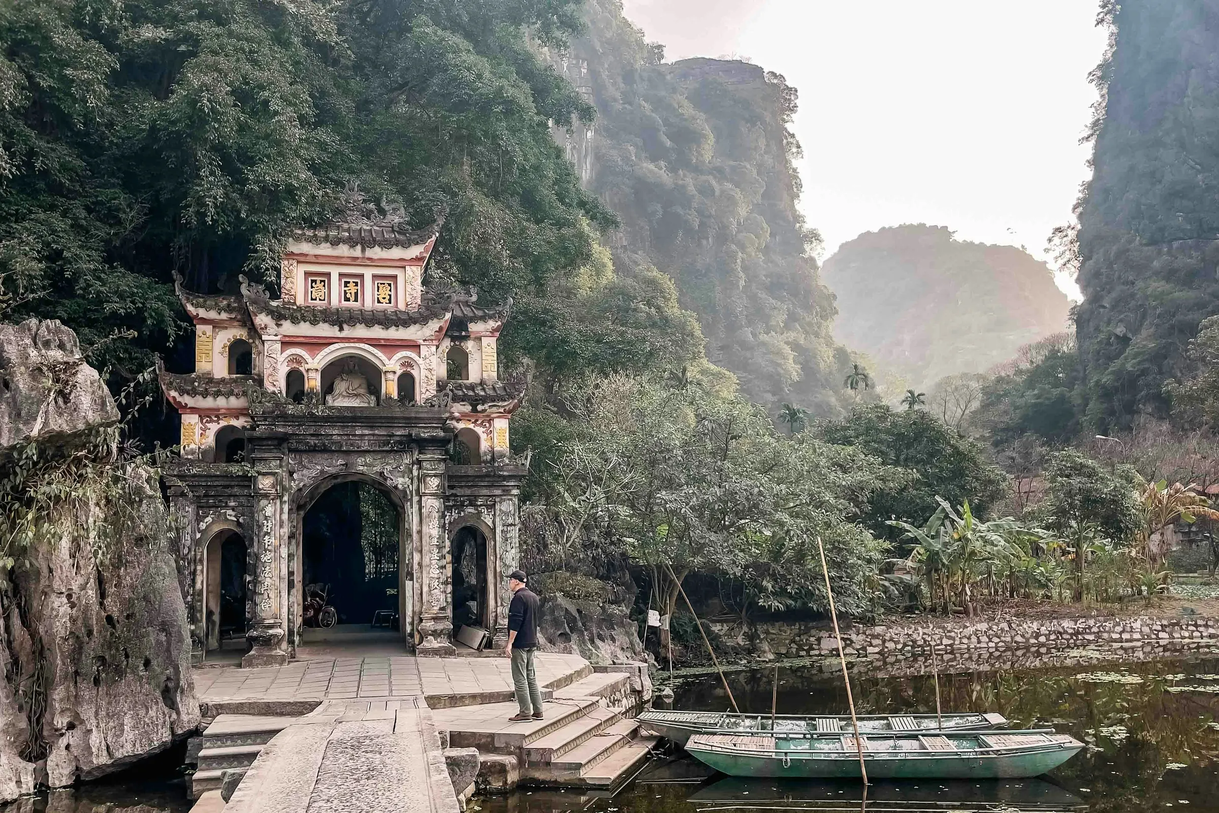 Tempelport ved en flod og kalkstensbjerge i Ninh Binh