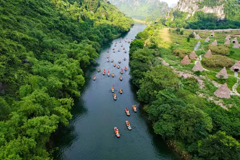 Både på en flod mellem grønne kalkstensbjerge i Ninh Binh