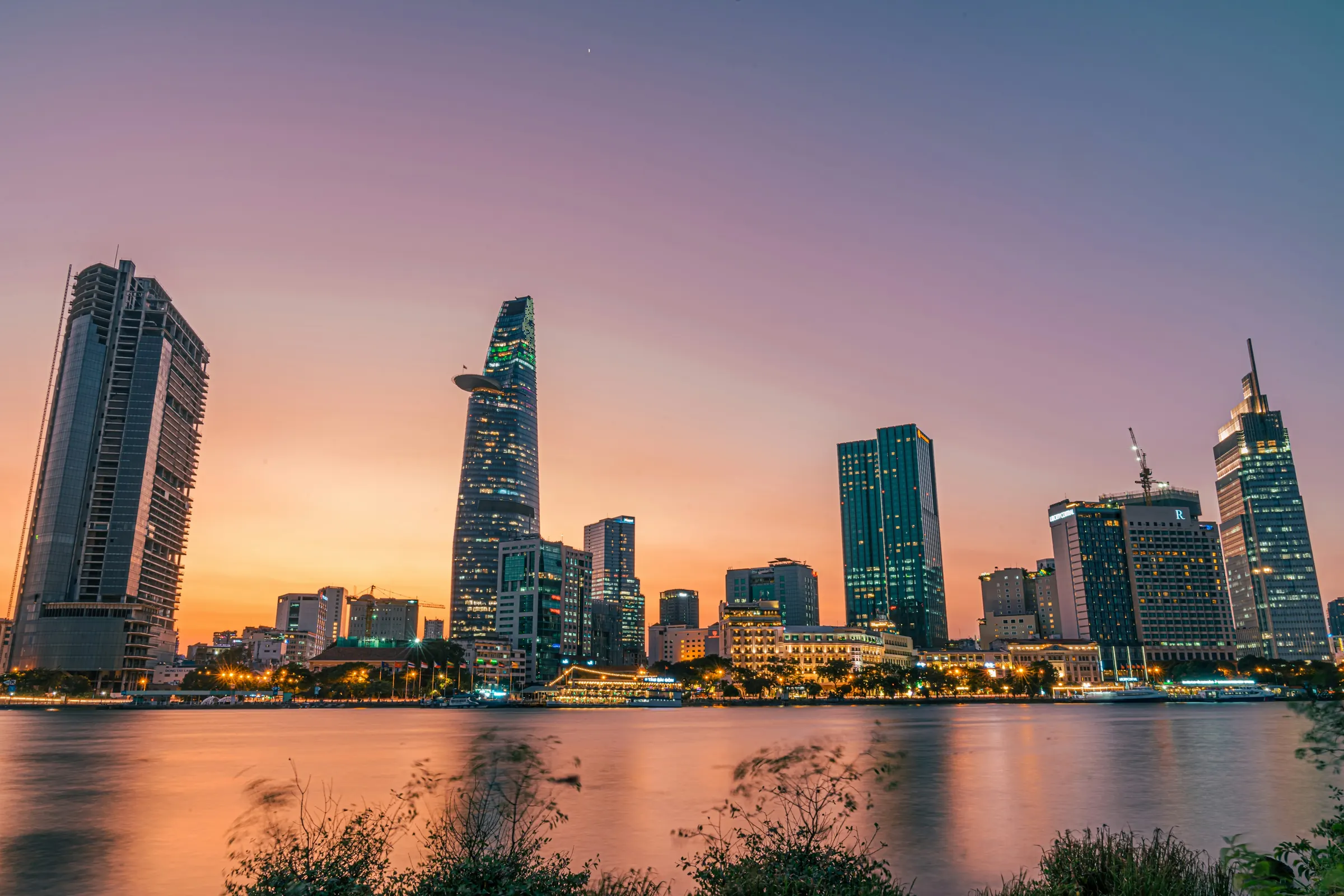 Ho Chi Minh-byens skyline ved floden i aftenskumringen