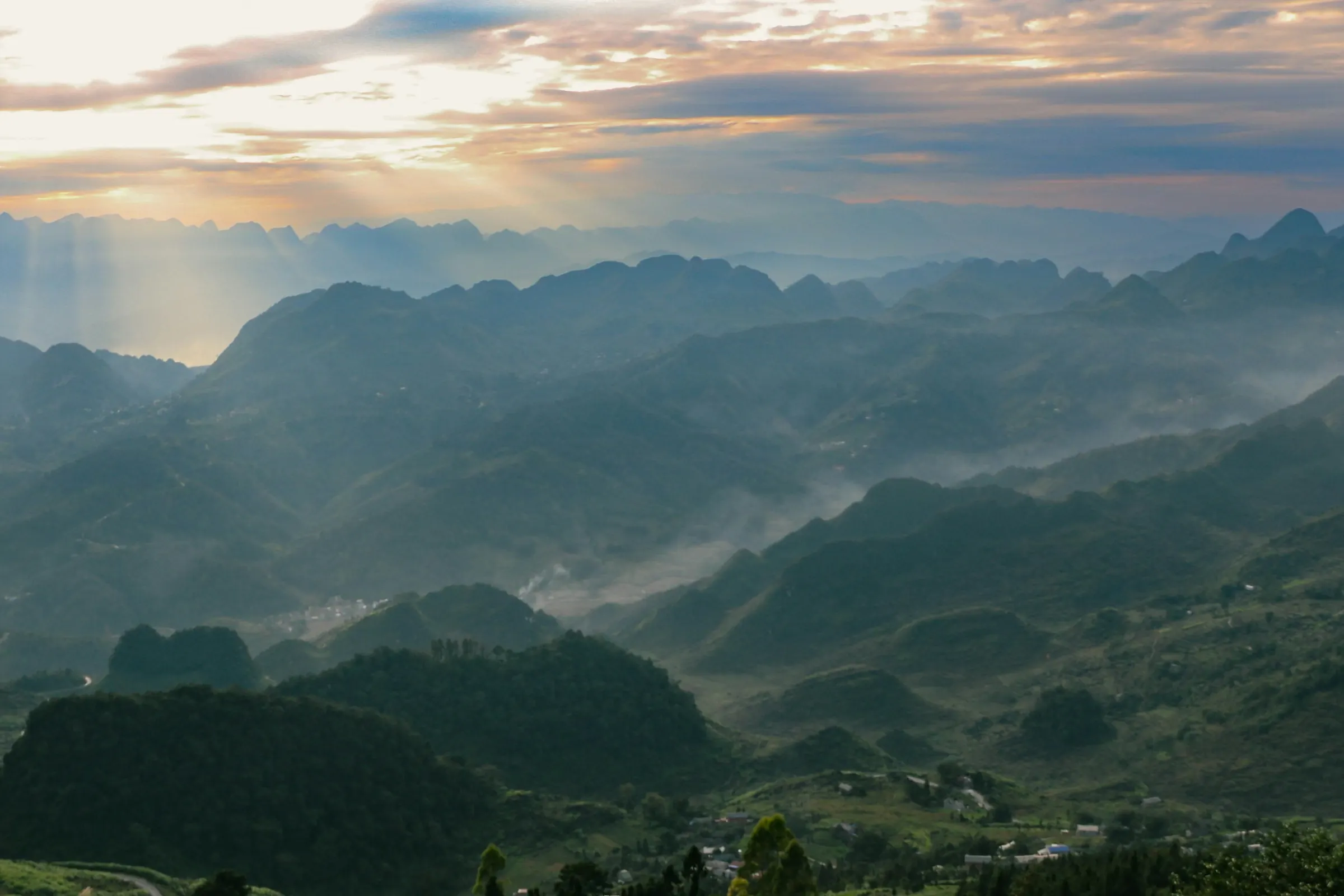 Solstråler over bjerge på Ha Giang-ruten