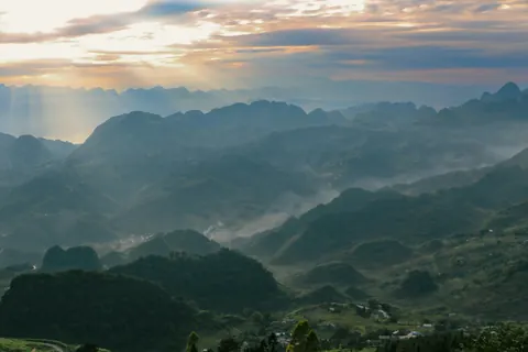 Solstråler over bjerge på Ha Giang-ruten
