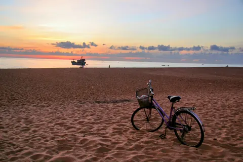 En cykel på stranden ved Dong Hoi