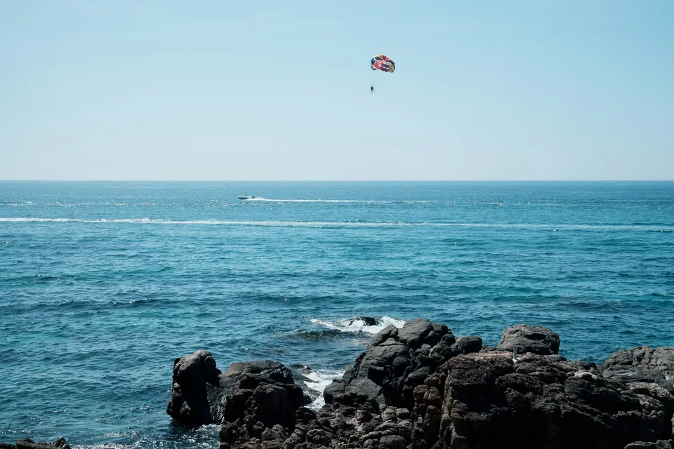 Klipper og blåt hav ved Quy Nhon med parasailing
