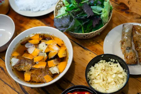 Bun cha-servering med risnudler, urter, sauce og små skåle med tilbehør