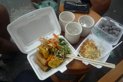 Takeawaymåltid med stegte forårsruller, ris og drikkevarer i Ho Chi Minh-byen