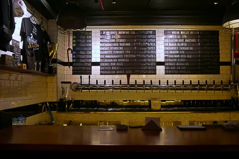 Bar med ølhaner og menutavle hos 7 Bridges Brewing i Ho Chi Minh-byen